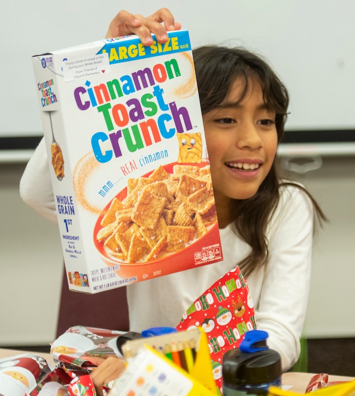 (Rick Egan  |  The Salt Lake Tribune)   Laylani Eontalez, 3rd grade, shows her classmates the box of cereal she opened. Ms. Worthington the principal, surprised all 650 students at her school with the gift-wrapped boxes of cereal, at Oquirrh Elementary in West Jordan, Thursday, Dec. 20, 2018.


