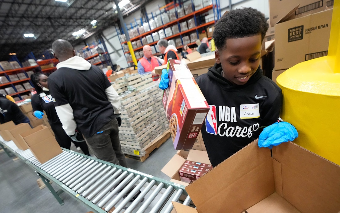 (Francisco Kjolseth | The Salt Lake Tribune) Chase Noel, 10, packs boxes with food during the NBA Cares Day of Service in Salt Lake City on Feb. 17, 2023.