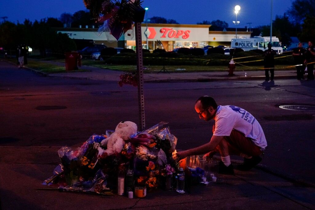 (Matt Rourke | AP Photo) A person pays his respects outside the scene of a shooting at a supermarket, in Buffalo, N.Y., Sunday, May 15, 2022.