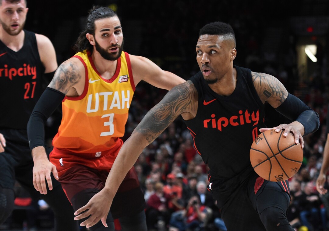 Portland Trail Blazers guard Damian Lillard, right, drives to the basket past Utah Jazz guard Ricky Rubio, left, during the first half of an NBA basketball game in Portland, Ore., Wednesday, April 11, 2018. The Blazers won 102-93. (AP Photo/Steve Dykes)