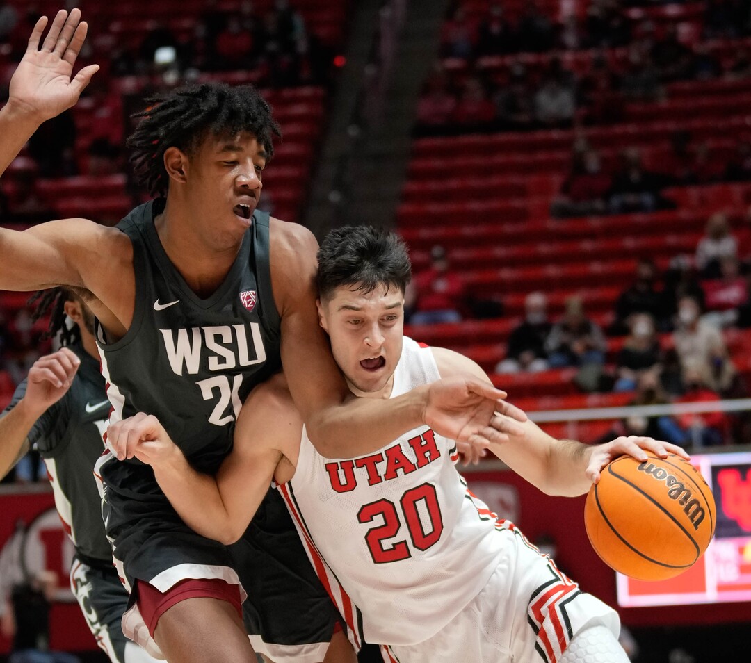 (Francisco Kjolseth | The Salt Lake Tribune) Washington State Cougars center Dishon Jackson (21) tries to block Utah Utes guard Lazar Stefanovic (20) during an NCAA college basketball game at the Jon M.Huntsman Center, on Saturday, Jan. 8, 2022. Utah lost 61-77.