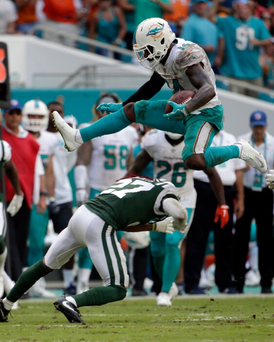 Miami Dolphins wide receiver Jarvis Landry (14) jumps over New York Jets cornerback Darryl Roberts (27), during the second half of an NFL football game, Sunday, Oct. 22, 2017, in Miami Gardens, Fla. (AP Photo/Lynne Sladky)