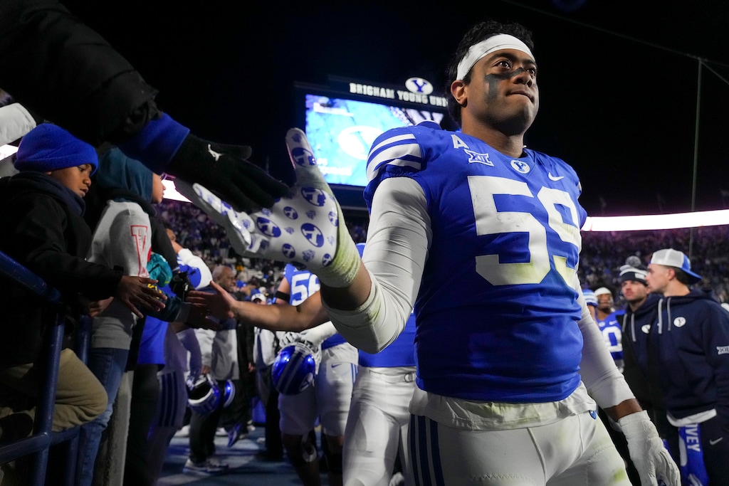 (Bethany Baker | The Salt Lake Tribune) Brigham Young Cougars defensive end Logan Lutui (59) high fives fans after the game against the Kansas Jayhawks in Provo on Sunday, Nov. 17, 2024.