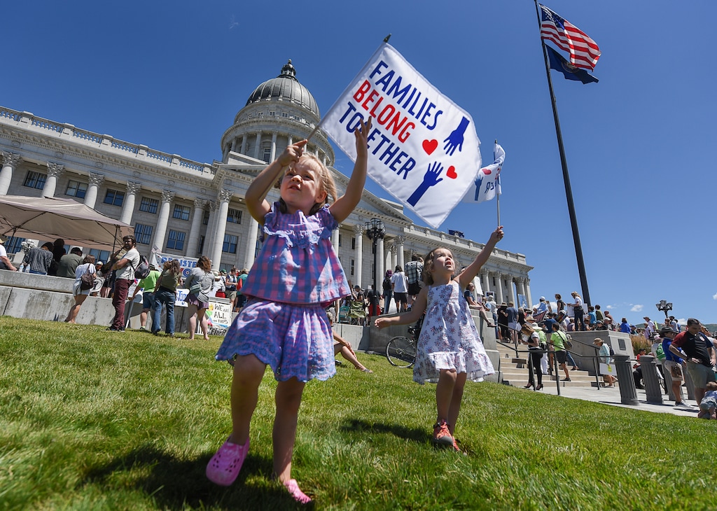 (Francisco Kjolseth | The Salt Lake Tribune) Madeline Nelson, left, is joined by her friend Sophie Hudiburg as their families join the crowd gathered at the Utah Capitol on Saturday, June 30, 2018, to protest the Trump administration's immigration policies that have led to the separation of migrant families. More than 750 locations around the country planned to participate in the 'Families Belong Together' event, including at the nations capitol.