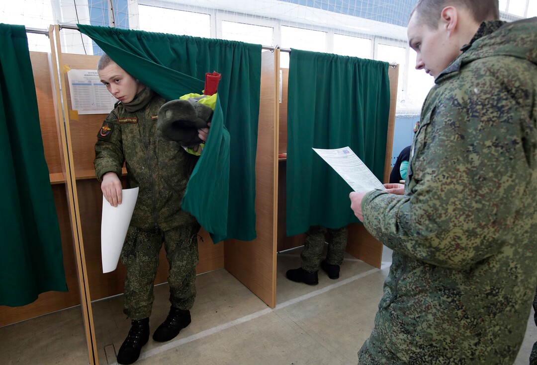 Russian servicemen vote in the Russian presidential election in St. Petersburg, Russia, Sunday, March 18, 2018. Russians are voting in a presidential election in which Vladimir Putin is seeking a fourth term in the Kremlin. (AP Photo/Dmitri Lovetsky)