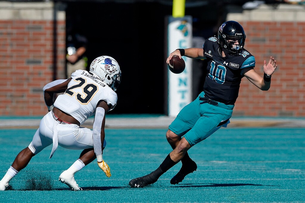 Coastal Carolina quarterback Grayson McCall (10) scrambles as Appalachian State's Brendan Harrington pursues during the first half of an NCAA college football game, Saturday, Nov. 21, 2020, in Conway, S.C. (AP Photo/Richard Shiro)