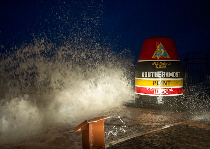 (Rob O'Neal/The Key West Citizen via AP) Waves crash against the Southernmost Point in Key West, Fla., Saturday, Sept. 9, 2017. Hurricane Irma's leading edge bent palm trees and spit rain as the storm swirled toward Florida on Saturday.