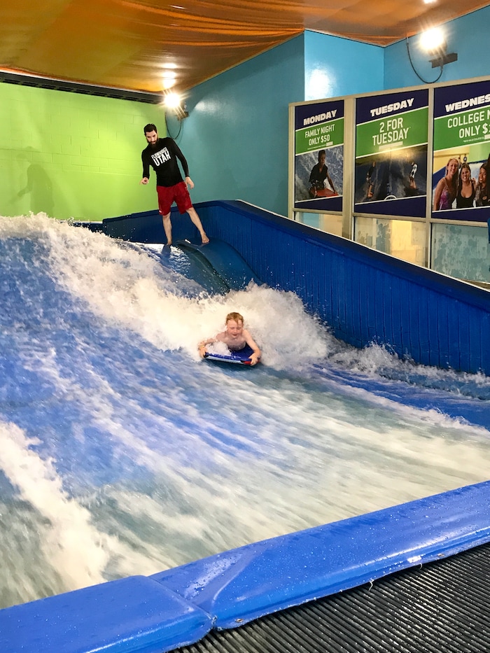 (Heather May | Special to The Tribune) Aided by instructor Jacob Berger, Luke, 8, tries surfing and boogie boarding at Flowrider in Ogden.