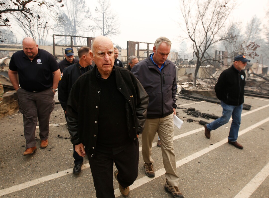 California Gov. Jerry Brown, center, and Interior Secretary Ryan Zinke, second from right, tour the fire ravaged Paradise Elementary School Wednesday, Nov. 14, 2018, in Paradise, Calif. The school is among the thousands of homes and businesses destroyed along with dozens of lives lost when the fire burned through the area last week. (AP Photo/Rich Pedroncelli)