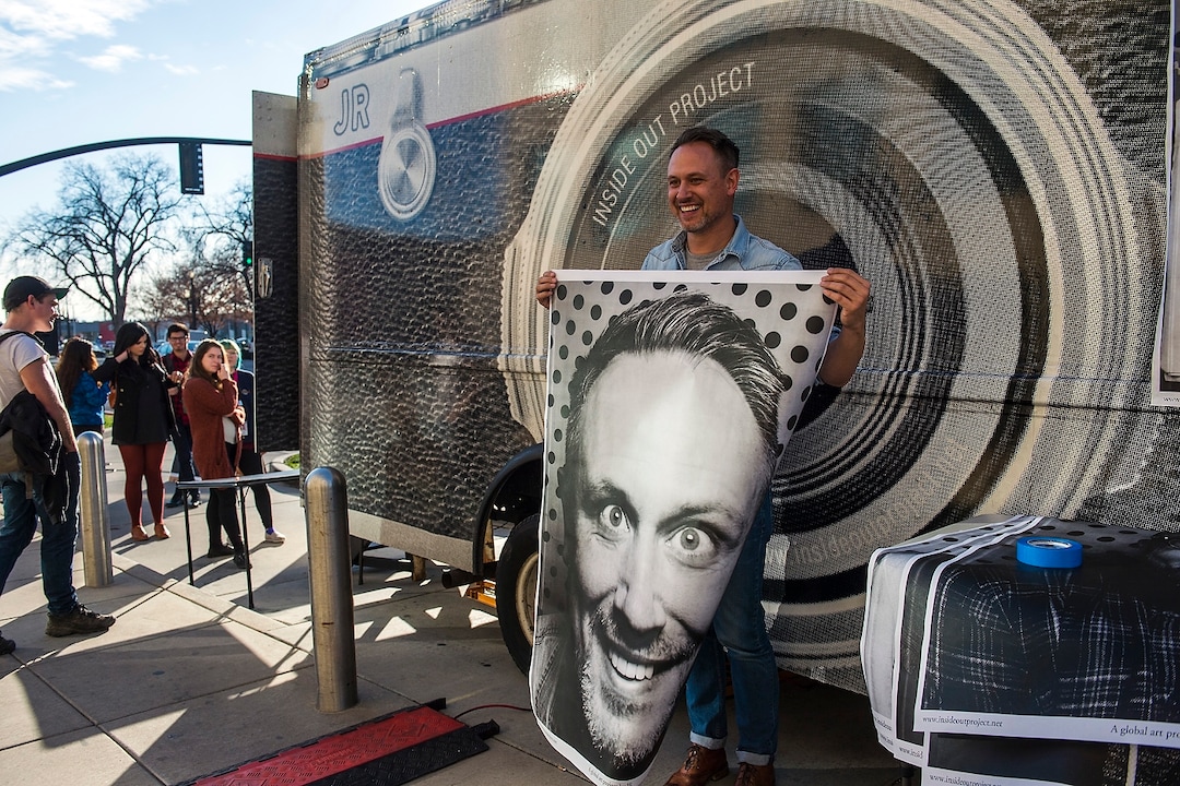 (Chris Detrick  |  The Salt Lake Tribune)  David Clyde, of Salt Lake City, holds his portrait from the photo truck during the Inside Out/Dreamers Project at the Salt Lake City Public Library Tuesday, November 21, 2017.  The Inside Out Project is a global participatory art project that gives everyone the opportunity to share their portrait and express what they stand for. In Utah, the future of more than 10,500 DACA recipients is being threatened by President Trump's decision to end the popular and successful DACA program.