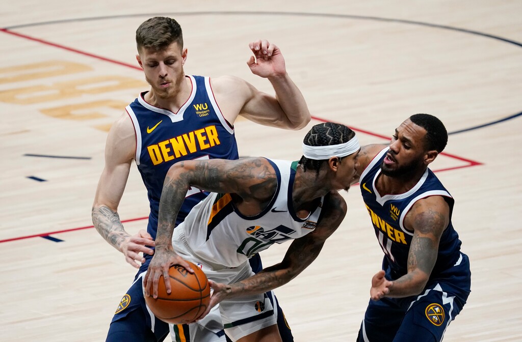 Utah Jazz guard Jordan Clarkson, front left, is trapped in the corner with the ball by Denver Nuggets guard Monte Morris, front right, and center Isaiah Hartenstein in the first half of an NBA basketball game Sunday, Jan. 17, 2021, in Denver. (AP Photo/David Zalubowski)