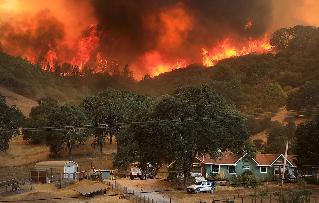 Flames from a wildfire advance down a hillside, towering over homes off Scotts Valley Road, Thursday, Aug. 2, 2018, near Lakeport, Calif. (Kent Porter /The Press Democrat via AP)