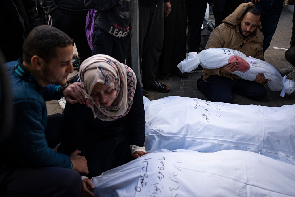 (Fatima Shbair | AP) Palestinians mourn relatives killed in the Israeli bombardment of the Gaza Strip at a hospital morgue in Rafah, Wednesday, Feb. 21, 2024.