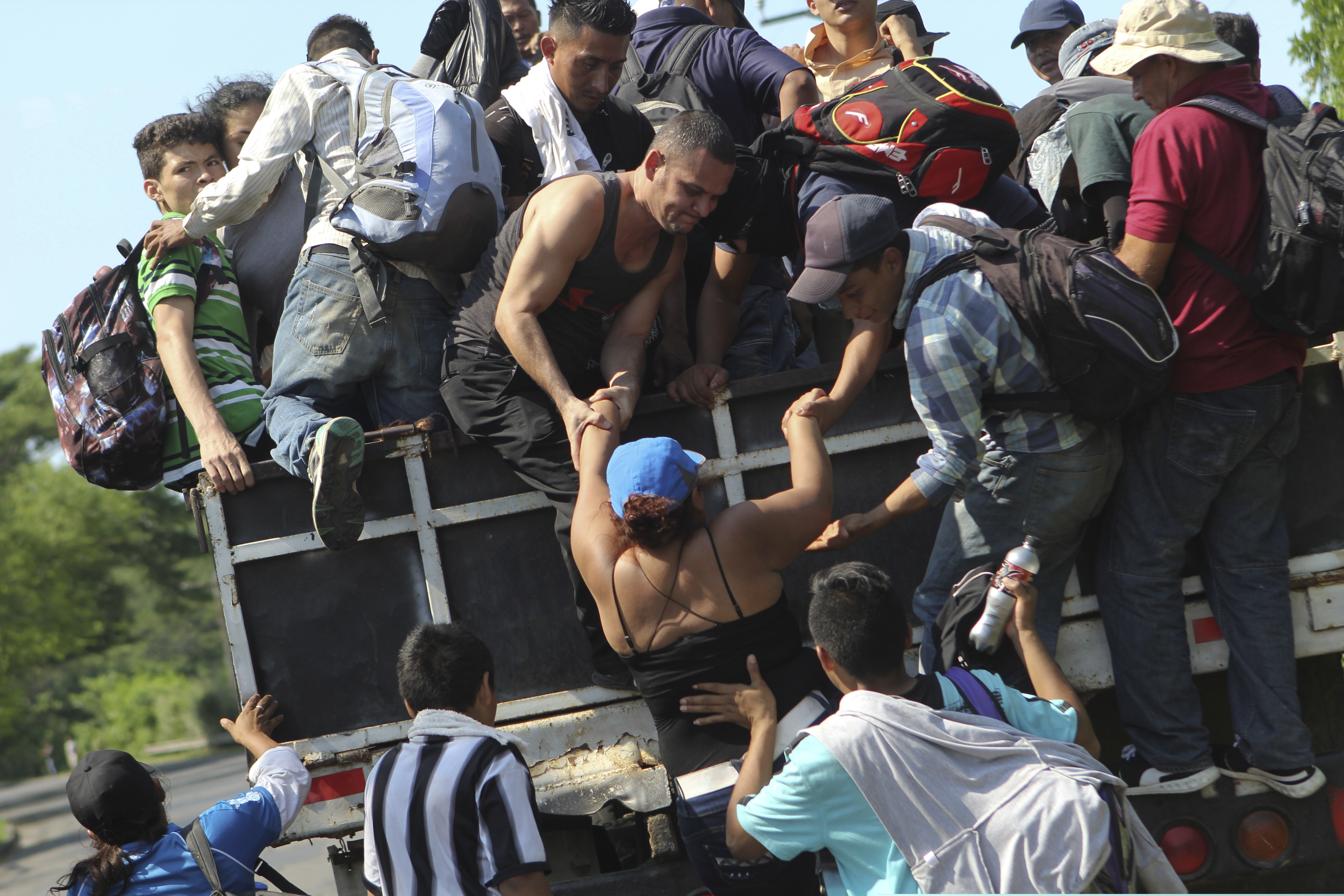 (Diana Ulloa | The Associated Press) Migrants from El Salvador board a truck as they start on their way to the United States, from San Salvador, El Salvador, Wednesday, Oct. 31, 2018. A third group of migrants from El Salvador had already made it to Guatemala, and on Wednesday a fourth group of about 700 Salvadorans set out from the capital, San Salvador, with plans to walk to the U.S. border, 1,500 miles away.
