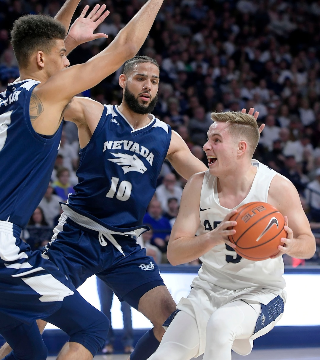 (Eli Lucero  |  The Herald Journal via AP) Utah State guard Sam Merrill (5) looks to shoot the ball as Nevada forward Trey Porter and forward Caleb Martin (10) defend during an NCAA college basketball game Saturday, March 2, 2019, in Logan, Utah.