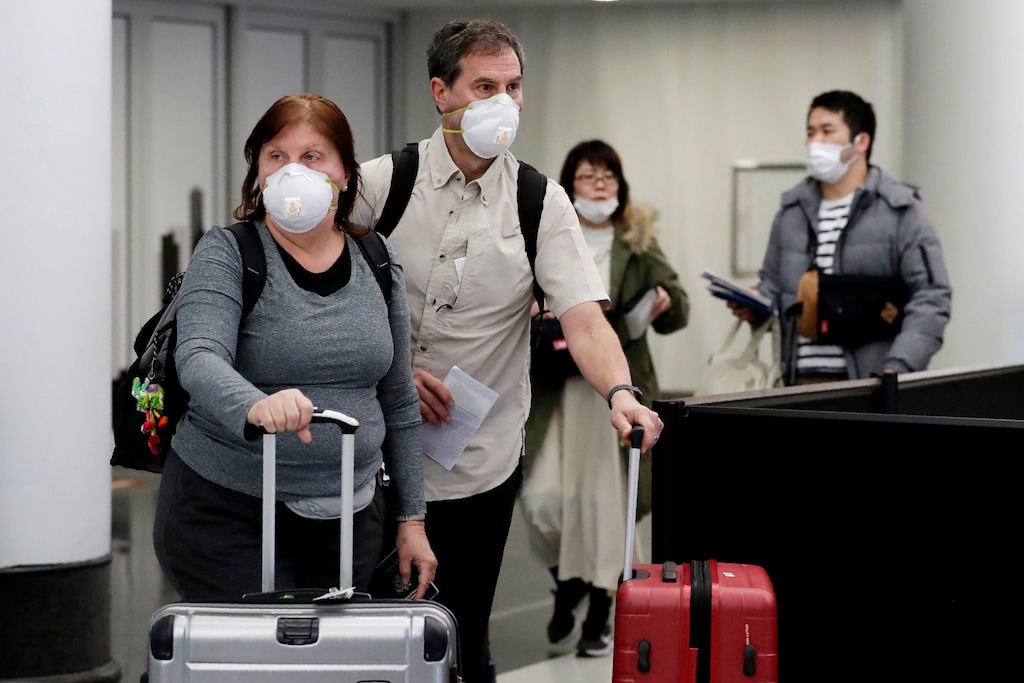 (Nam Y. Huh | AP)  Travelers wear protective mask as they walk through in terminal 5 at O'Hare International Airport in Chicago, Sunday, March 1, 2020.