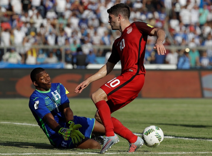 United States' Christian Pulisic, right, fights for the ball with Honduras goalkeeper Luis Lopez during a 2018 World Cup qualifying soccer match in San Pedro Sula, Honduras, Tuesday, Sept. 5, 2017. (AP Photo/Rebecca Blackwell)