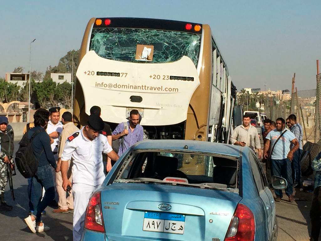 (Mohammed Salah | The Associated Press) Police inspect a car and a bus that were damaged by a bomb, in Cairo, Egypt, Sunday, March 19, 2019. Egyptian officials say a roadside bomb has hit a tourist bus near the Giza Pyramids. They said Sunday’s blast wounded at least 17 people, including tourists.