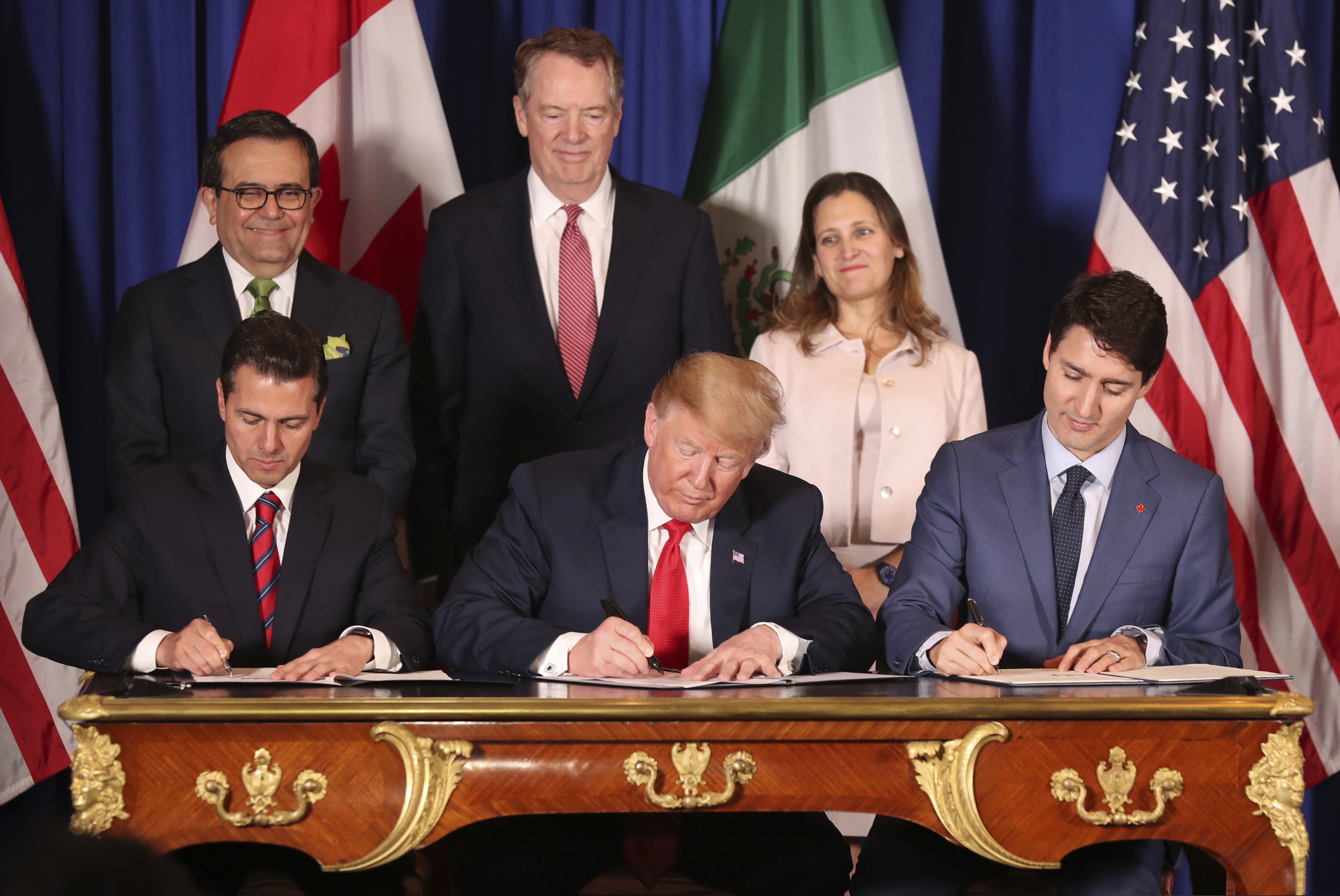 (Martin Mejia | AP) In this Nov. 30, 2018 file photo, President Donald Trump, center, sits between Canada's Prime Minister Justin Trudeau, right, and Mexico's President Enrique Pena Nieto as they sign a new United States-Mexico-Canada Agreement that is replacing the NAFTA trade deal, during a ceremony at a hotel before the start of the G20 summit in Buenos Aires, Argentina. Trump’s new North America trade agreement would give the U.S. economy only a modest boost, an independent federal agency finds.