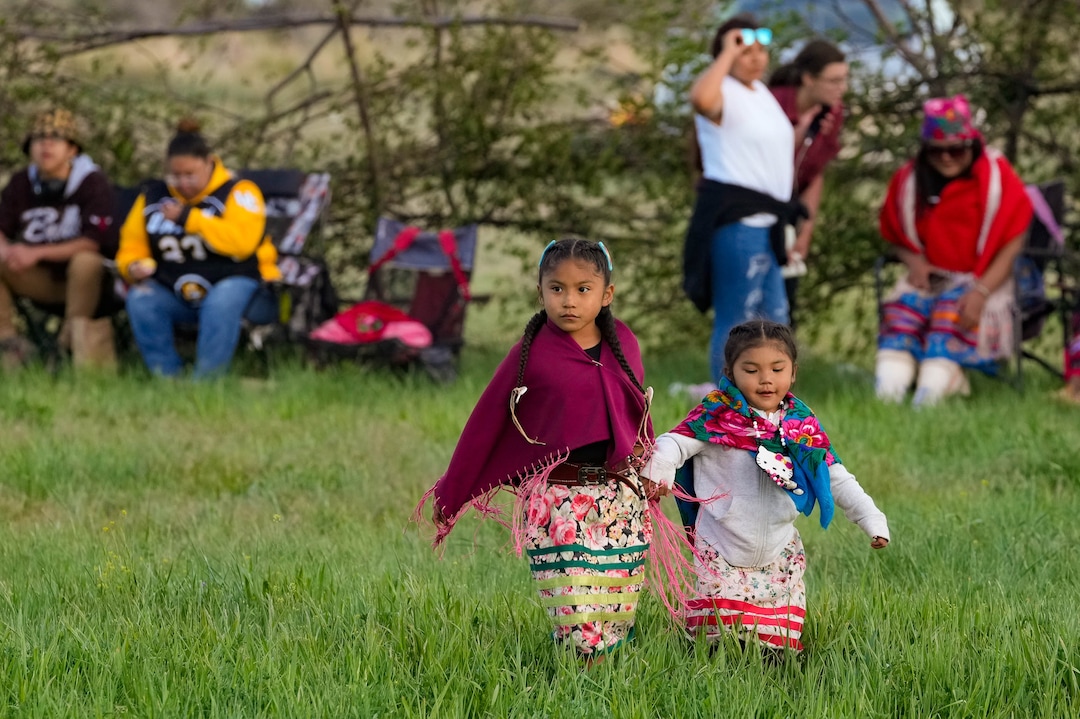 (Francisco Kjolseth | The Salt Lake Tribune) Young dancers make the walk across the field for a “ladies choice,” selection of male dancers on the other side of a large ring made of woven willow sticks as part of a traditional Bear Dance in Whiterocks, Utah on Thursday, May 19, 2022.