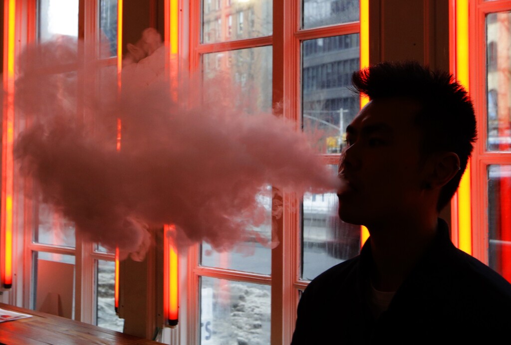 (AP file photo) A patron exhales vapor from an e-cigarette at the Henley Vaporium in New York, as seen in 2014.  A new Utah survey conducted in 2017 indicates that nearly 59.8 percent of Utah youths who reported using alcohol in the prior 30 days also used e-cigarettes or a vaping device.