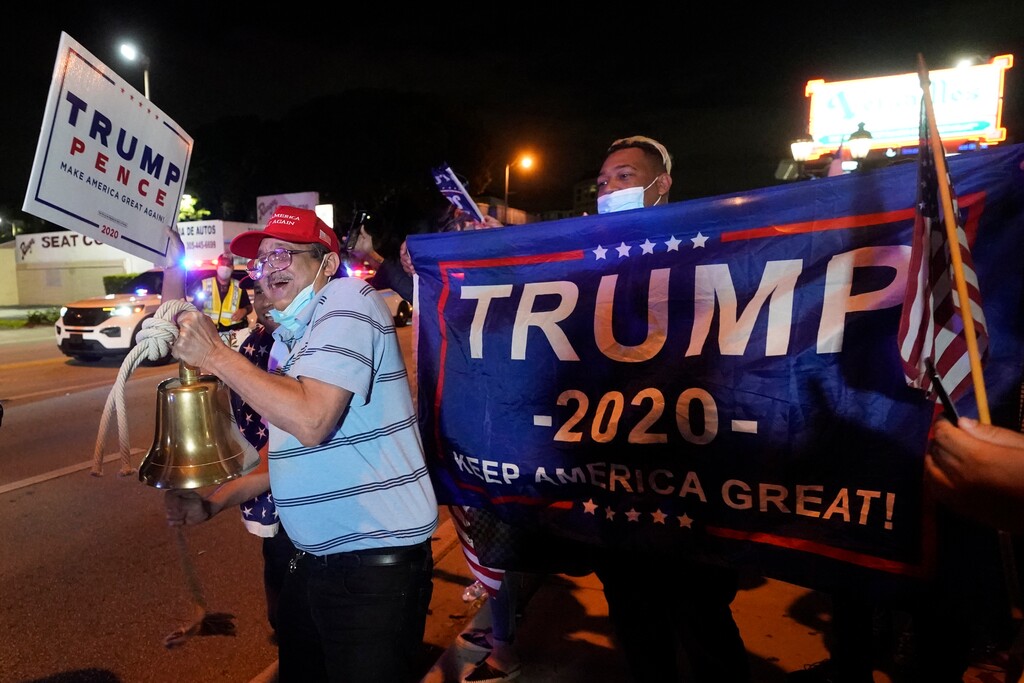 (Wilfredo Lee | AP photo)
In this Nov. 3 photo, Rafael Fagundo rings a bell as he and other supporters of President Donald Trump chant and wave flags outside the Versailles Cuban restaurant during a celebration on election night in the Little Havana neighborhood of Miami. As election postmortems go, the one that began in Florida Wednesday was especially wrenching for Democrats. While they could share in the possibility of a Biden victory, as other battleground states continue to tally votes, the soul searching and second-guessing has begun amid another high-profile loss at the ballot box.