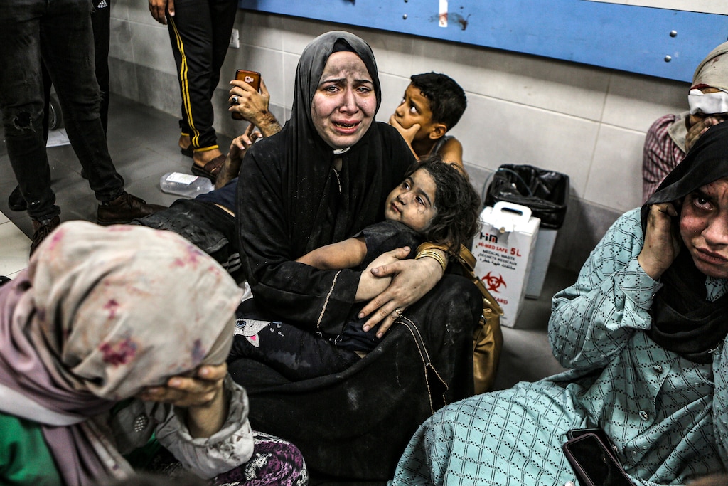 (Abed Khaled | AP) Palestinians wounded at Ahli Arab hospital sit on the floor at al-Shifa hospital, in Gaza City, central Gaza Strip, Tuesday, Oct. 17, 2023. The Hamas-run Health Ministry says an Israeli airstrike caused an explosion that killed hundreds at the Ahli Arab hospital, but the Israeli military says it was a misfired Palestinian rocket.