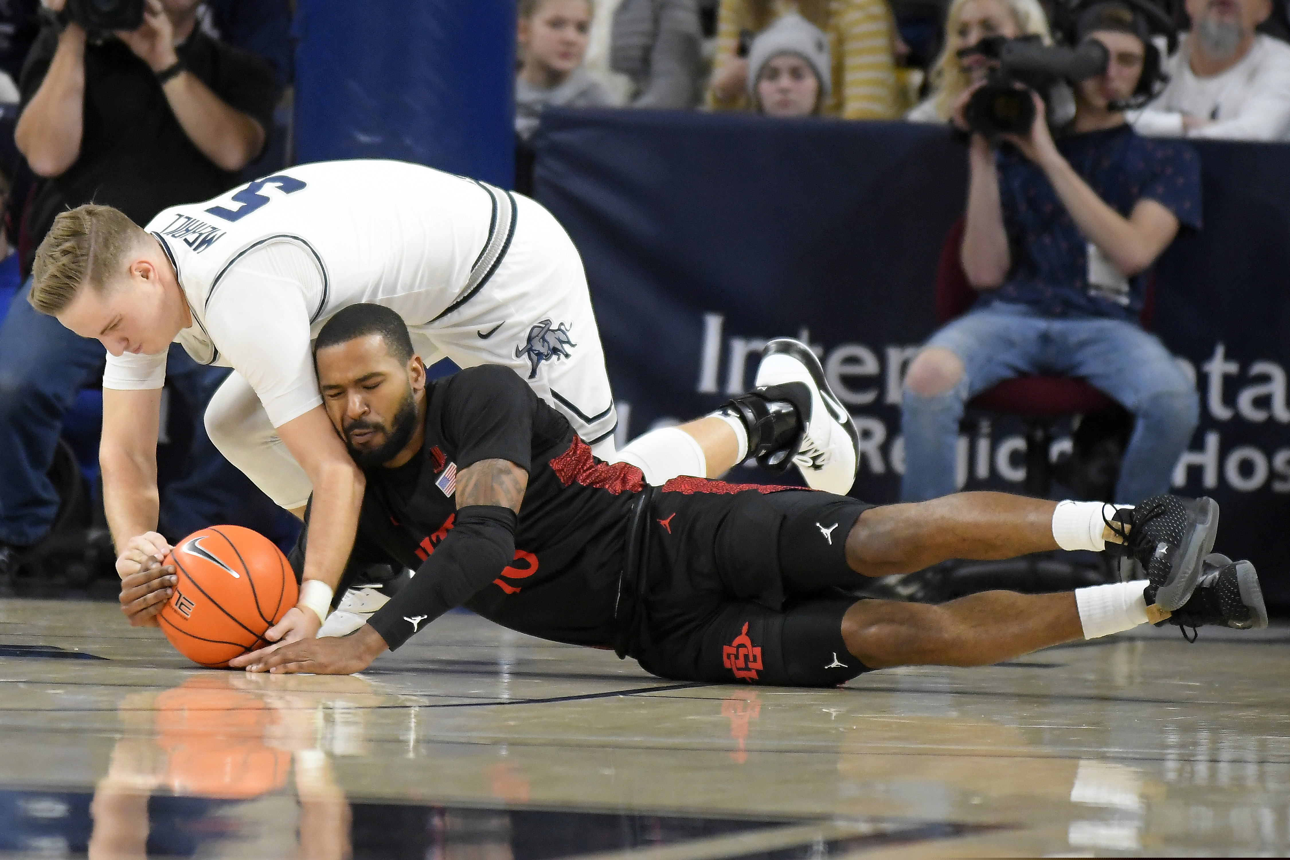Utah State guard Sam Merrill (5) and San Diego State guard KJ Feagin (10) scramble for the ball during the first half of an NCAA college basketball game Saturday, Jan. 4, 2020, in Logan, Utah. (AP Photo/Eli Lucero)