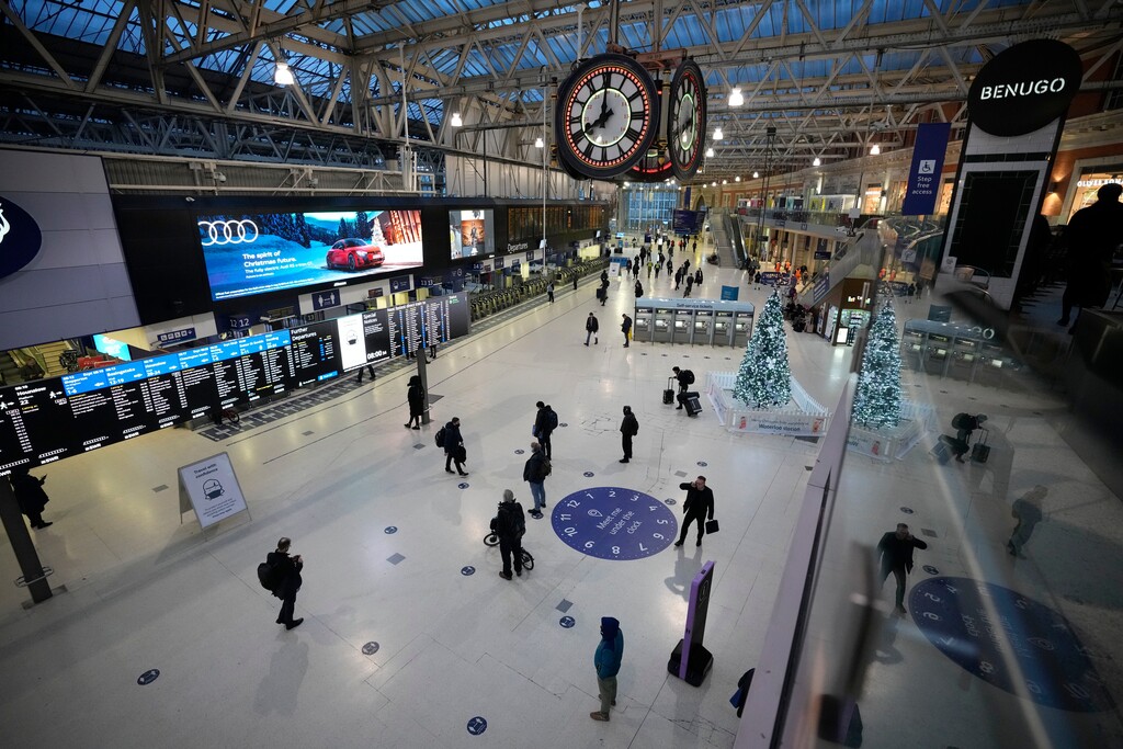 (Matt Dunham | AP) People pass through during the morning rush hour at Waterloo railway station in London, Tuesday, Dec. 14, 2021. As of Monday in England, people were urged to work from home if possible, with long lines forming at vaccination centers for people to get booster shots to protect themselves against the coronavirus omicron variant.