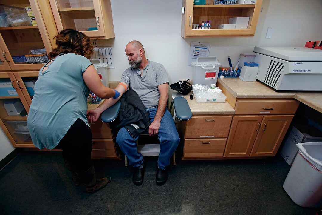 (Luis Sánchez Saturno | Santa Fe New Mexican | The Associated Press) In this Wednesday, April 25, 2018 photo, Andrea Rodriguez, clinical research coordinator, draws blood from Patrick Coss at Southwest Care in Santa Fe, N.M. The  HIV/AIDS clinic has been at the forefront of AIDS research over the past 30 years.