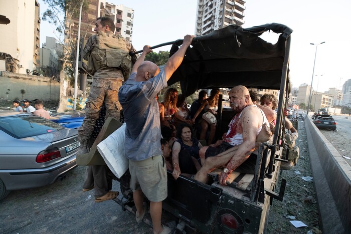 Army soldiers evacuate injured people after a massive explosion in Beirut, Lebanon, Tuesday, Aug. 4, 2020. Massive explosions rocked downtown Beirut on Tuesday, flattening much of the port, damaging buildings and blowing out windows and doors as a giant mushroom cloud rose above the capital. Witnesses saw many people injured by flying glass and debris. (AP Photo/Hassan Ammar)