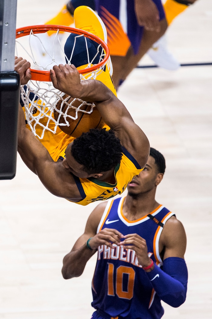(Chris Detrick  |  The Salt Lake Tribune)  Utah Jazz guard Donovan Mitchell (45) dunks over Phoenix Suns guard Shaquille Harrison (10) during the game at Vivint Smart Home Arena Thursday, March 15, 2018. 