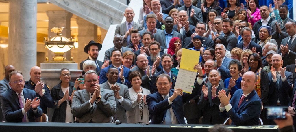 (Rick Egan | Tribune file photo) This April 2, 2019, file photo shows Utah Gov. Gary Herbert holding up a copy of the hate crimes bill signed into law after years of unsuccessful attempts to enact such legislation. After 25 years with no enforceable hate crimes law, prosecutors have begun filing charges and, in some cases, winning convictions in these cases. FBI annual crime statistics, though, dramatically underreport these crimes.