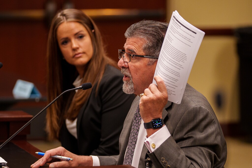 (Trent Nelson | The Salt Lake Tribune) Dave Spatafore holds up the UHSAA's policy on transgender athletes, as Rep. Kera Birkeland, R-Morgan, looks on during meeting of the Health and Human Services Interim Committee at the State Capitol in Salt Lake City on Wednesday, June 16, 2021. For the second year in a row, Birkeland is proposing legislation that would limit transgender girls' participation in Utah high school sports.