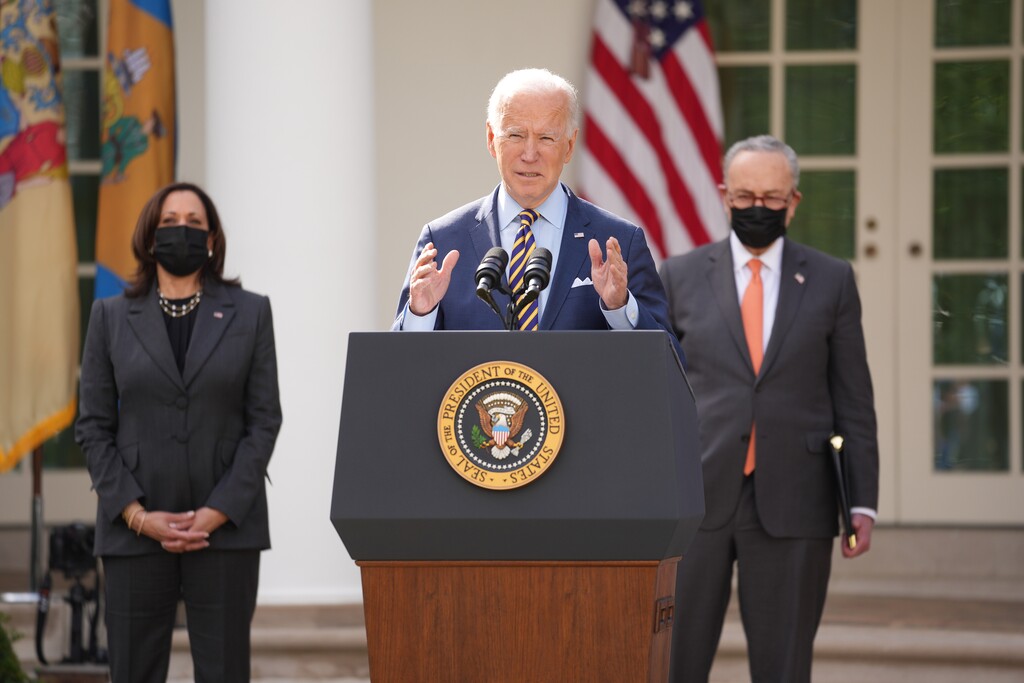 (Doug Mills | The New York Times) President Joe Biden delivers remarks on the American Rescue Plan in the Rose Garden of the White House in Washington, March 12, 2021, as Vice President Kamala Harris and Senate Majority Leader Chuck Schumer (D-N.Y.) look on. Twenty-one Republican attorneys general pressed the Biden administration on March 16 to clarify a provision in the $1.9 trillion economic aid package that the president signed into law last week, warning that its restrictions on state efforts to cut taxes could be “the greatest attempted invasion of state sovereignty by Congress in the history of our Republic.”