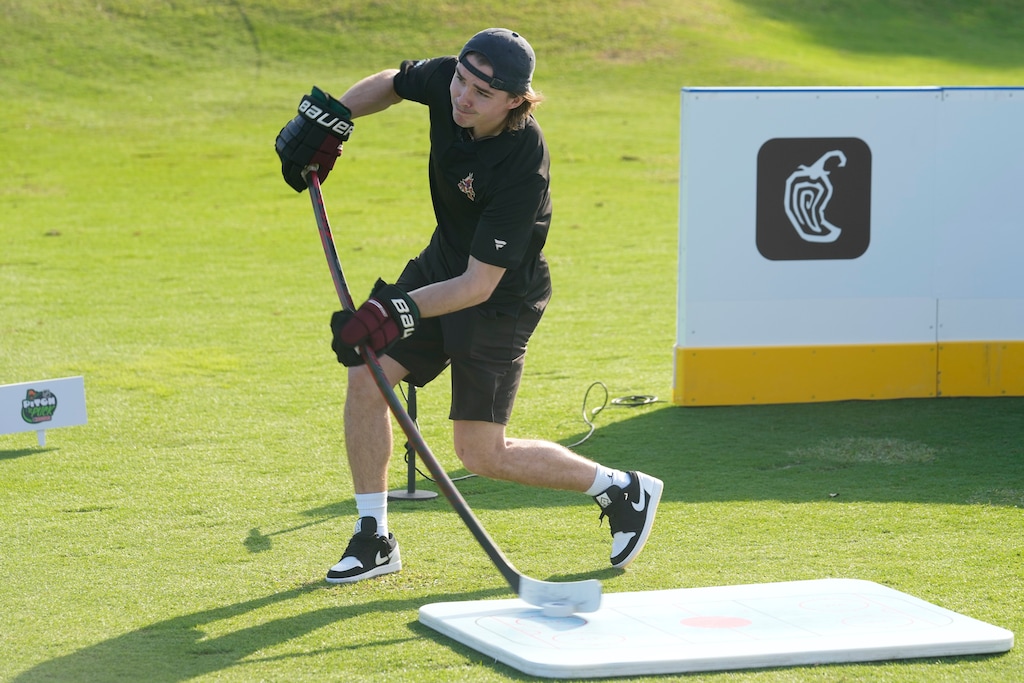 (Marta Lavandier | AP) Utah Hockey Club forward Clayton Keller, then a member of the Arizona Coyotes, hits his first shot with a hockey stick during a golf skills competition, Wednesday, Feb. 1, 2023, in Plantation, Fla. The event was part of the NHL All Star weekend.
