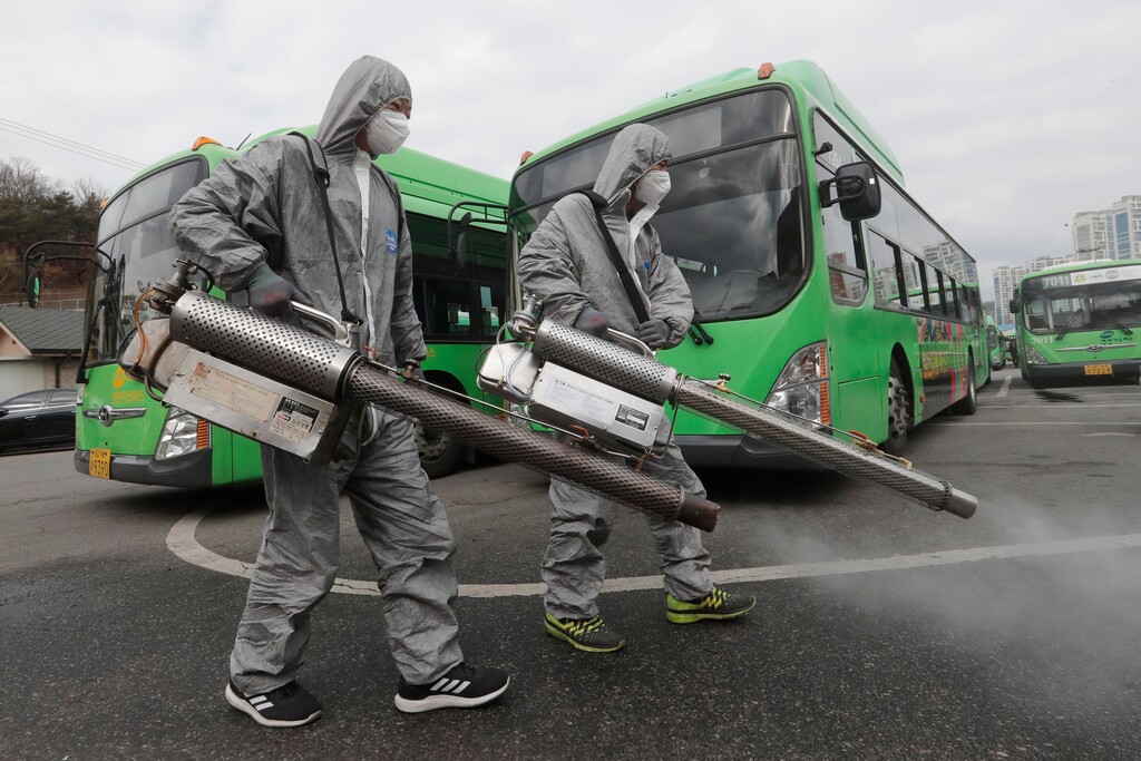 (Ahn Young-joon | AP) Workers wearing protective suits spray disinfectant as a precaution against the coronavirus at a bus garage in Seoul, South Korea, Wednesday, Feb. 26, 2020.