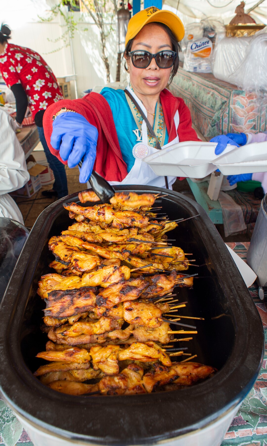 (Rick Egan  |  The Salt Lake Tribune)     Khamvang Kaykeo  dishes up some grilled chicken, during the Wat Lao Salt Lake Buddharam Utah, New Year Celebration, in West Valley City, Sunday, April 28, 2019.