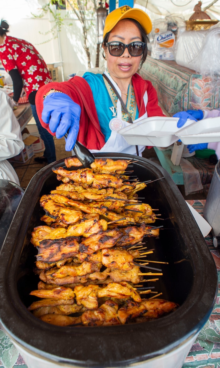 (Rick Egan  |  The Salt Lake Tribune)     Khamvang Kaykeo  dishes up some grilled chicken, during the Wat Lao Salt Lake Buddharam Utah, New Year Celebration, in West Valley City, Sunday, April 28, 2019.


