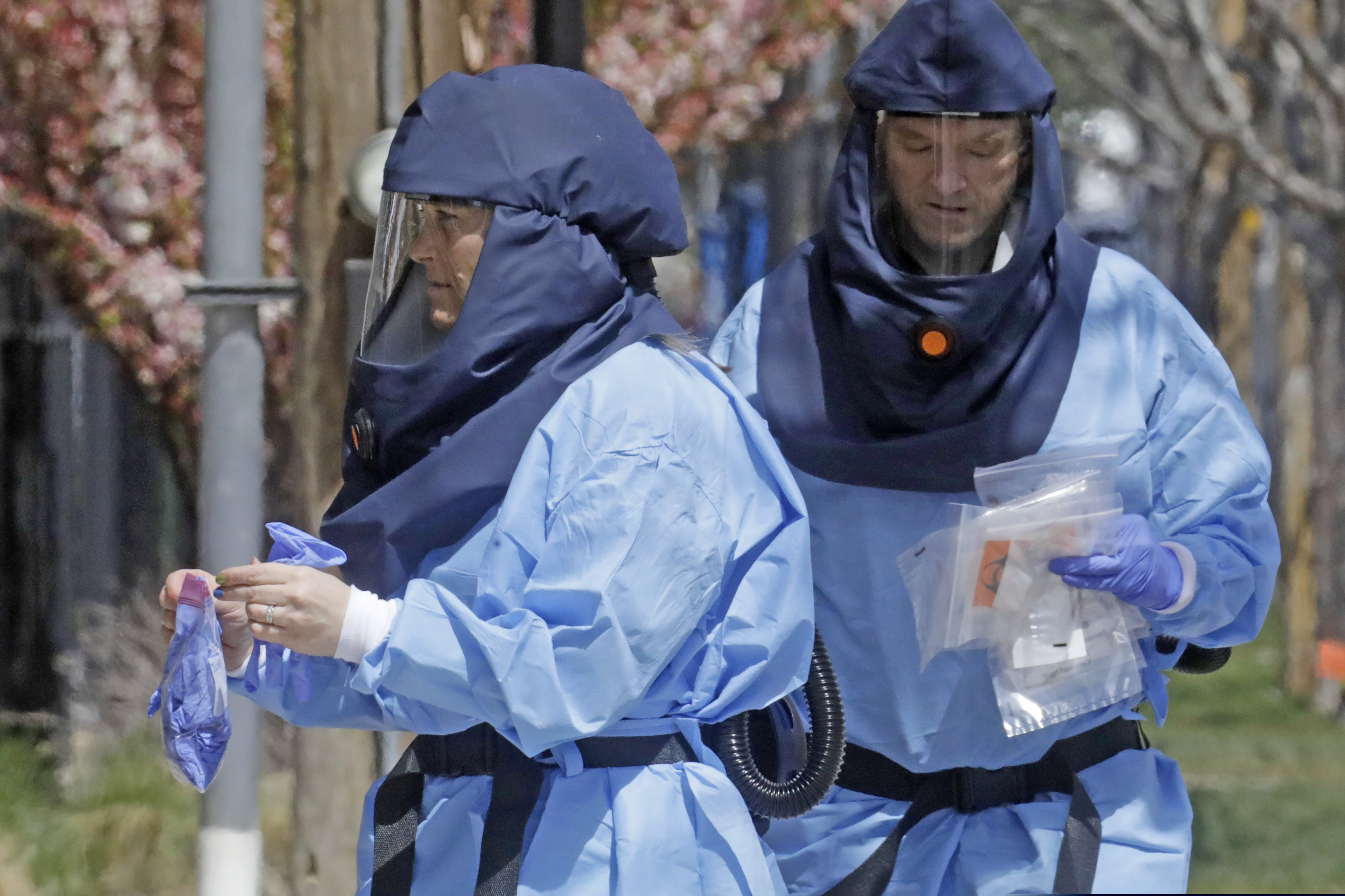 AP Photo/Rick Bowmer) Health care workers walk to the Salt Lake City Public Health Center after administering a COVID-19 test Monday, April 13, 2020, in Salt Lake City.