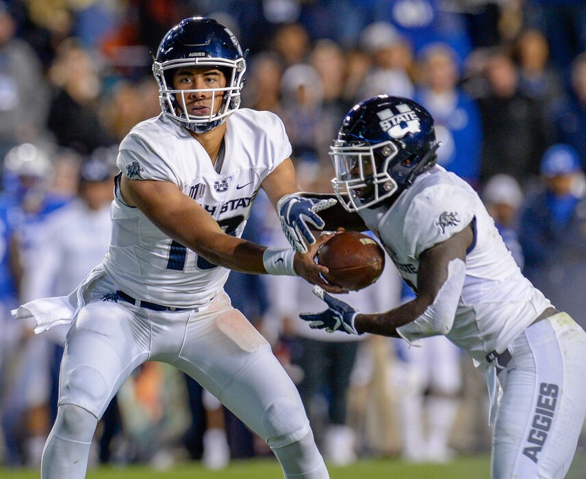 Leah Hogsten | The Salt Lake Tribune Utah State Aggies quarterback Jordan Love (10) hands the ball to Utah State Aggies running back Gerold Bright (8). Utah State University defeated BYU 45-20 at Lavell Edwards Stadium in Provo, Friday, Oct. 5, 2018.
