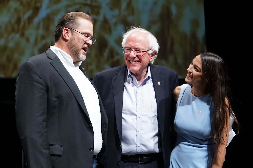 Kansas congressional candidate James Thompson, left, U.S Sen. Bernie Sanders, I-Vt.,  and Alexandria Ocasio-Cortez, a Democratic congressional candidate from New York, stand together on stage after a rally, Friday, July 20, 2018, in Wichita, Kan. (Jaime Green/The Wichita Eagle via AP)
