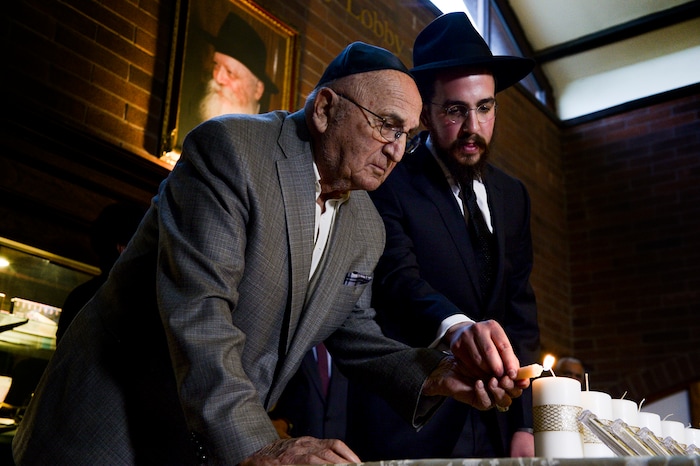 Leah Hogsten | The Salt Lake Tribune Holocaust survivor Abe Katz is aided by Rabbi Avremi Zippel as 11 candles representing those killed during Saturday's shooting at the Tree of Life Synagogue in Pittsburgh are remembered during an interfaith service at Chabad Lubavitch of Utah, Monday, Oct. 29, 2018. Hundreds attended the vigil and prayer service to pray "for peace, harmony and love to once again reign supreme upon this Earth."