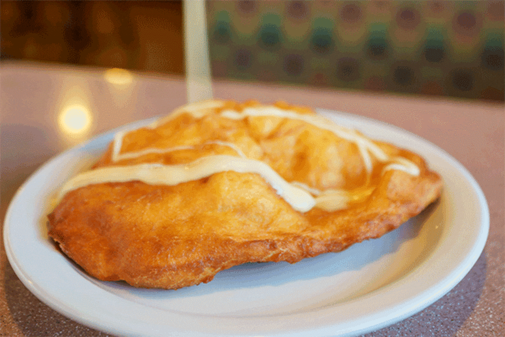 (Trent Nelson  |  The Salt Lake Tribune) A scone is slathered with honey butter at Midvale Mining Cafe on Wednesday, Aug. 17, 2022.