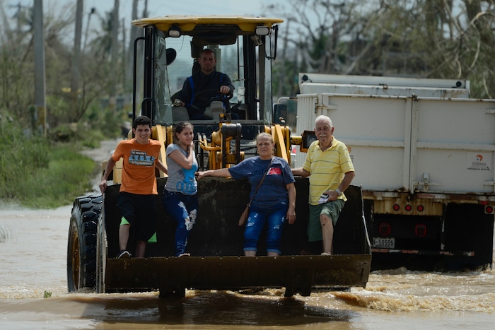 Residents ride a mechanical shovel through a flooded road after the passing of Hurricane Maria, in Toa Baja, Puerto Rico, Friday, September 22, 2017. Because of the heavy rains brought by Maria, thousands of people were evacuated from Toa Baja after the municipal government opened the gates of the Rio La Plata Dam. (AP Photo/Carlos Giusti)