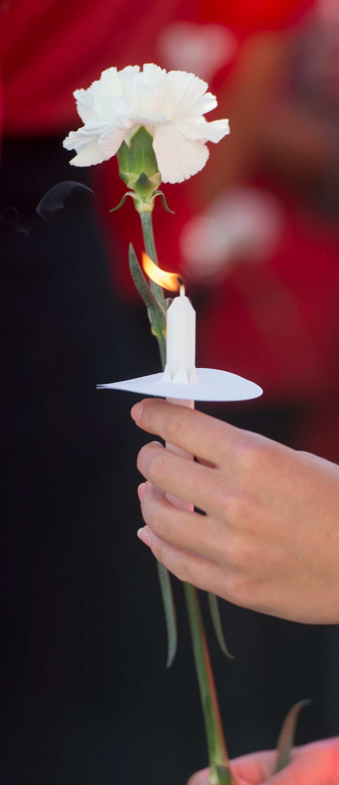 (Jeremy Harmon  |  The Salt Lake Tribune) A member of the University of Utah track team holds a flower and a candle during a vigil for teammate Lauren McCluskey on Wed. Oct 24, 2018. McCluskey was killed on campus on Monday.