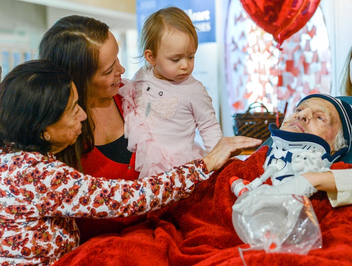 Leah Hogsten  |  The Salt Lake Tribune  l-r Lucia Silva, daughter Flavia Beare and granddaugher Petra Beare, caress the face of their husband and father, Osvaldo Silva. On Friday, Intermountain Hospital caregivers wheeled paralyzed cancer patient Osvaldo Silva, 85, down to the lobby for a personal piano concert in his honor, Feb. 15, 2019. With tears streaming down his face, Osvaldo, who is from Brazil, was treated to a dozen songs played by his Church of Jesus Christ of Latter-day Saints bishop, Bispo Do Pai Valdir, who kicked off the set with none other than ÒThe Girl from Ipanema.Ó  