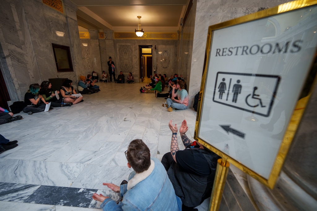 (Trent Nelson  |  The Salt Lake Tribune) Activists in support of transgender rights hold a sit-in in front of a bathroom at the Utah Capitol in Salt Lake City on Thursday, Feb. 22, 2024.