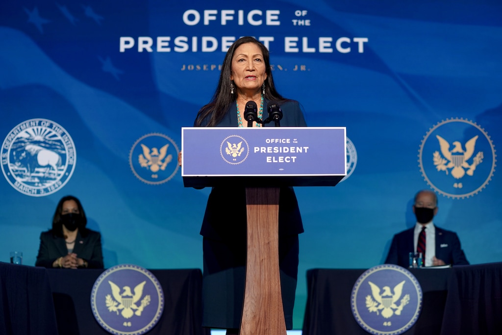(Amr Alfiky | The New York Times) Rep. Deb Haaland (D-N.M.) speaks to reporters in Wilmington, Del., on Dec. 19, 2020 as President-Elect Joe Biden and Vice President-elect Kamala Harris look on. Haaland is Biden's choice to lead the Interior Department and is the first Native American to be chosen as a cabinet secretary.