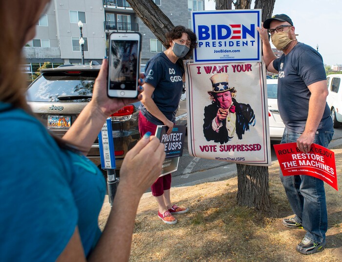 (Rick Egan  |  The Salt Lake Tribune)    Jamie Carter takes a photo of Ruth and George Angerbauer, during a rally to "Save the Post Office," hosted by Alliance for a Better Utah, NAACP Salt Lake Branch, League of Women Voters at the Post Office on 200 South in Salt Lake City, Saturday, Aug. 22, 2020.